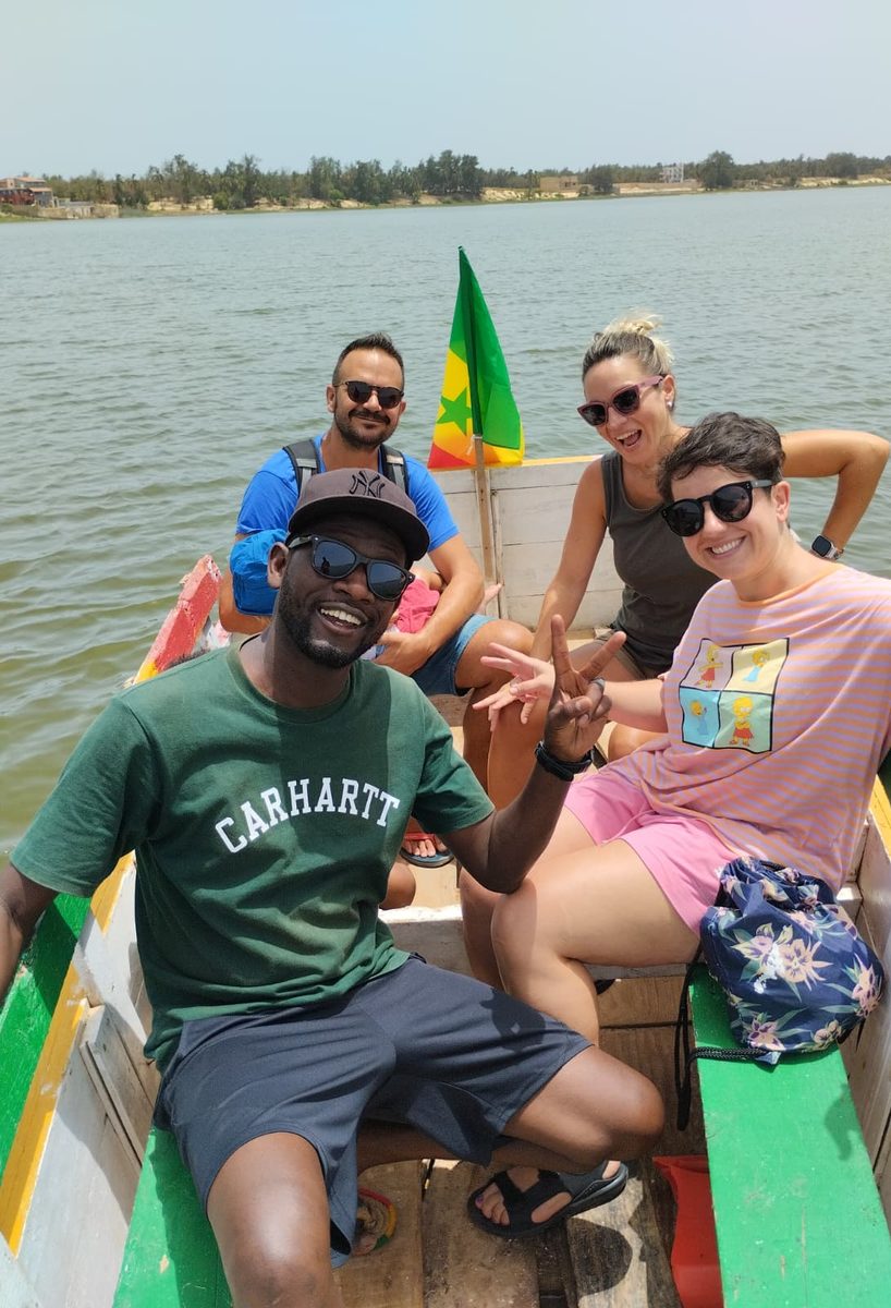 Hamdy con un grupo de viajeros en una piragua con la bandera de Senegal