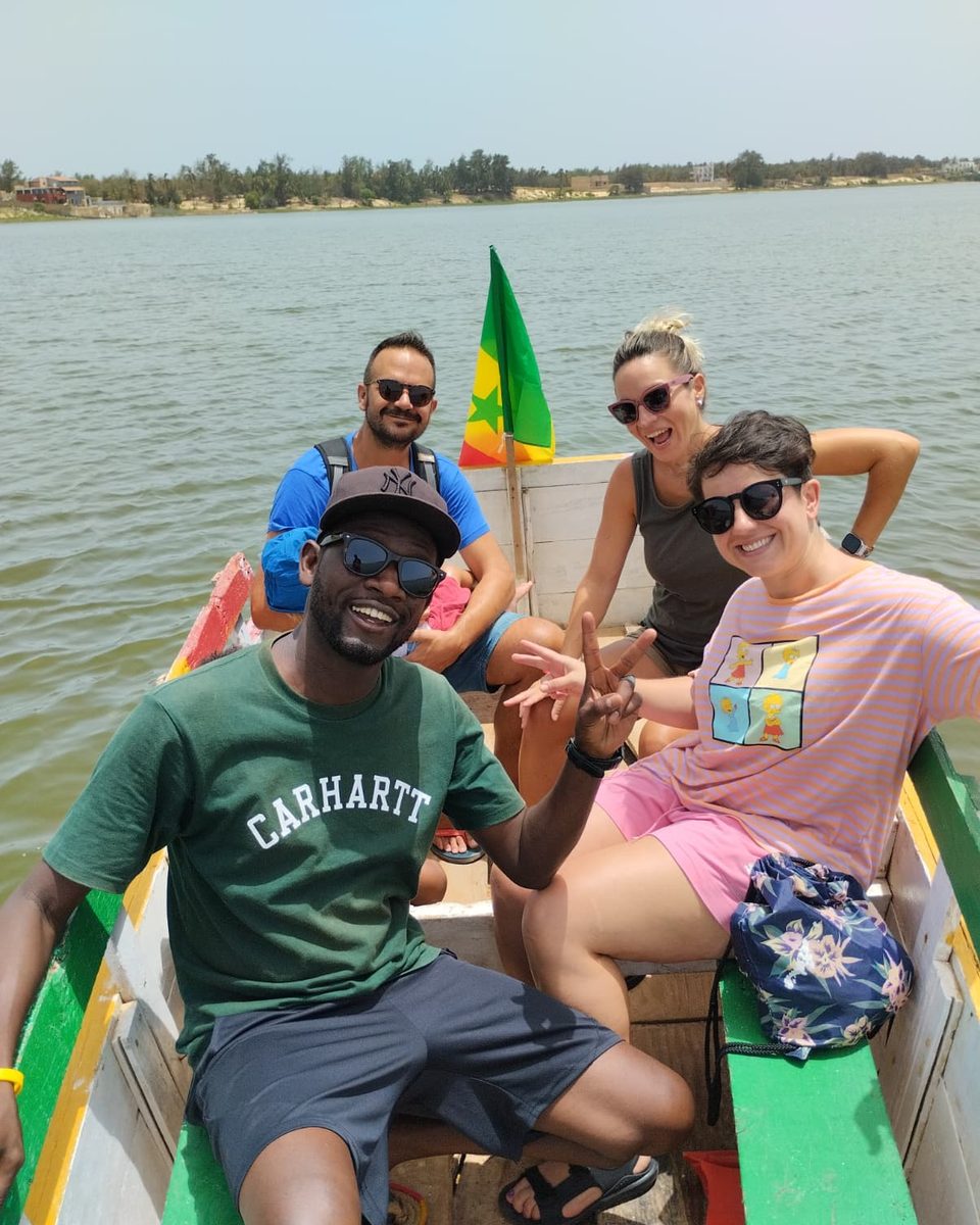 Hamdy con un grupo de viajeros en una piragua con la bandera de Senegal